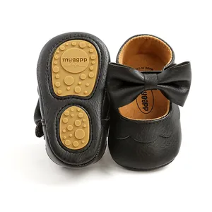 Close-up detail of black PU infant princess shoes featuring a large bow and non-slip soft sole