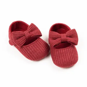 Close-up of red ribbed knit baby princess shoes with large bow for 0-1 year old infants