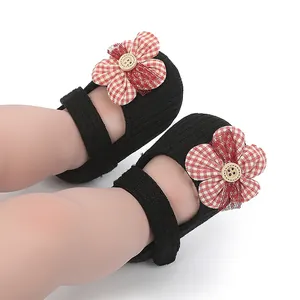 Primer plano de zapatos de bebé para niña con flores de cuadros y detalle de botón