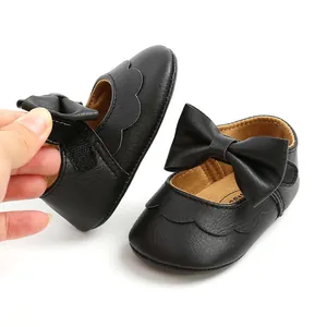 Detail view showing black PU leather baby princess shoes with elegant bow and velcro strap