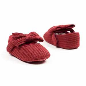 Detailed view of dark red ribbed knit baby girl shoes with cute bow design