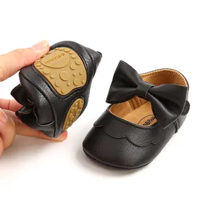 Close-up of flexible soft sole black PU baby princess shoes with a decorative bow