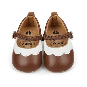 Vorderansicht von braun-weißen Baby-Lauflernschuhen mit geflochtenem Riemen.
