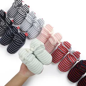 Gros plan de chaussons d'hiver rayés pour bébé avec doublure en polaire douce et chaude.