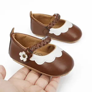 Detailansicht brauner Baby-Lauflernschuhe mit geflochtenem Riemen und weißer Blume