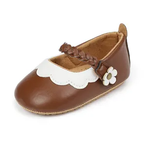 Detailansicht der braunen Baby-Lauflernschuhe mit weißer Blume und Flechtriemen
