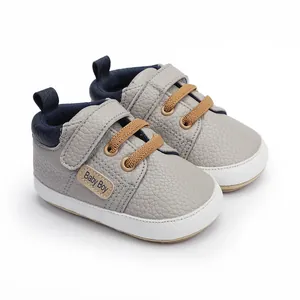Macro detail shot of grey baby boy walking shoes featuring soft faux leather texture