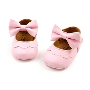 Detailed view of pink PU leather baby princess shoes with large bow and soft soles