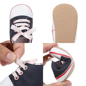 Detail view showing flexible soft sole infant walking shoes with pink ribbon laces
