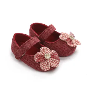Primer plano de zapatos de bebé niña rojos con flor a cuadros y detalle de botón