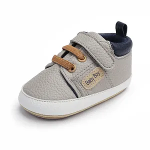 Detailed view of grey pebbled leather baby walking shoe with Baby Boy patch.