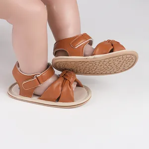 Detailed view of brown knotted baby sandals with non-slip soft sole for infants.