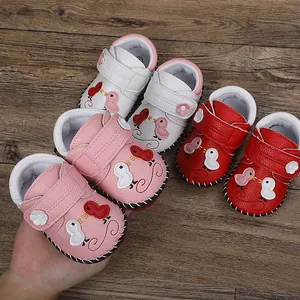 Detalle de tres pares de coloridos zapatos de bebé para caminar sobre madera
