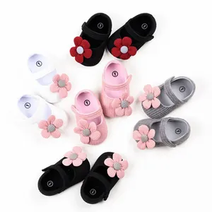 Vue détaillée de chaussures bébé tricotées à semelle souple avec fleurs décoratives