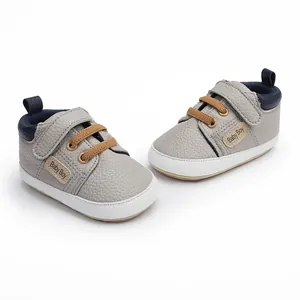 High-quality grey infant walking shoes featuring brown laces and Baby Boy side label