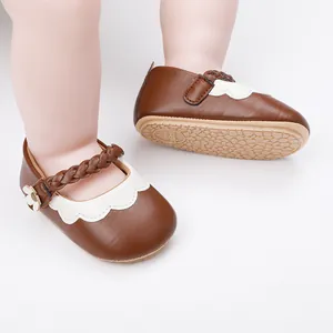 Detail von braunen Baby-Lauflernschuhen mit geflochtenem Riemen und rutschfester Sohle.