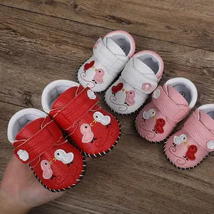 Primer plano de zapatos de bebé con dibujos animados y suelas cosidas a mano
