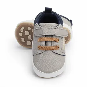 Close-up detail of grey infant walking shoes featuring textured upper and velcro strap