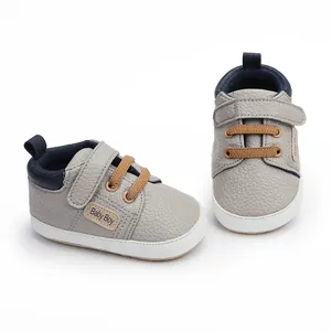Close-up of grey baby walker shoes with Velcro strap and 'Baby Boy' side tag detail.