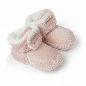 Detaillierte Nahaufnahme von rosa Baby-Booties aus Kord mit weichem weißem Kunstfellfutter