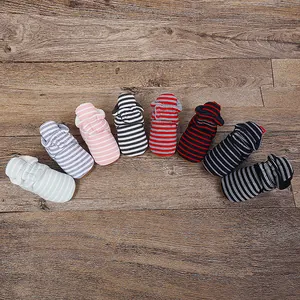 Vue détaillée de chaussons d'hiver rayés pour bébés sur une surface en bois