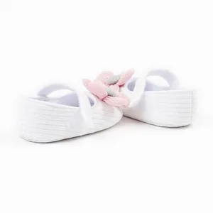 Side view detail of white baby girl princess walker shoes with pink knitted flower accent
