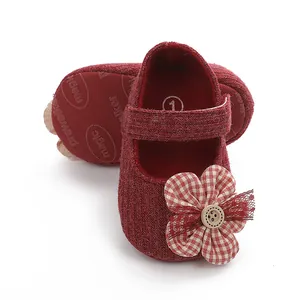 Macro detail of red fabric baby princess shoes featuring soft soles and floral decor