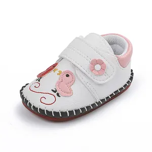 Primer plano de zapato de cuero para bebé con diseño de pato y detalle de flor rosada