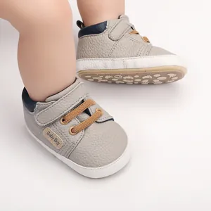 Detailed view of grey soft-sole baby walking shoes with velcro strap and tan laces