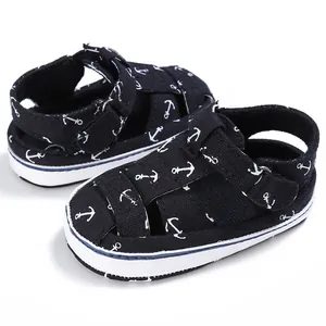 Detail view of navy baby walker sandals featuring white anchor patterns and canvas texture