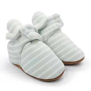 Détail de chaussons souples à rayures vertes et blanches pour bébé avec doublure polaire