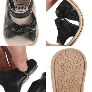 Detail view of black baby pre-walker sandals with soft bow and non-slip sole.