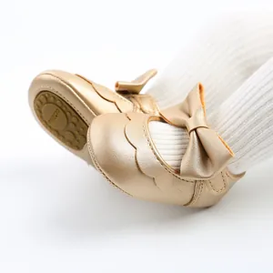Detailed view of gold metallic PU baby princess shoes with a large bow and soft anti-slip sole