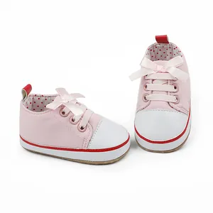 Cute pink baby pre-walker shoes with soft soles and decorative ribbon bows for infants.
