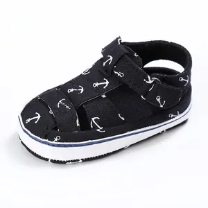 Detailed view of navy blue canvas baby pre-walker sandals featuring white anchor prints
