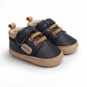 Detail showing navy blue baby pre-walker shoe with Baby Boy patch and Velcro strap