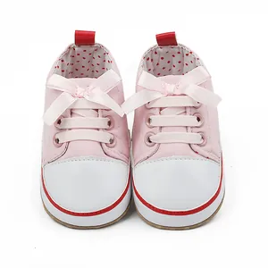 Close-up of pink baby pre-walker shoes with pink ribbon bows and polka dot lining