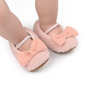 Primer plano de zapatos de bebé peludos rosa con lazo suave y correa