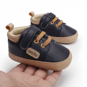 Close-up of navy blue baby pre-walker shoes with 'Baby Boy' label and velcro strap.