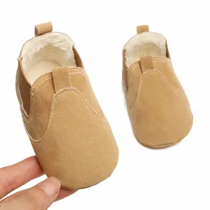 Gros plan sur la doublure en peluche et la texture en daim de ces chaussures de bébé