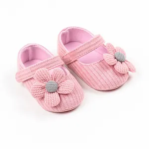 Detailed view of pink knitted baby girl princess walking shoes with large fabric flower