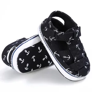 Detailed view of baby walking sandals featuring navy anchor patterns and white soles.