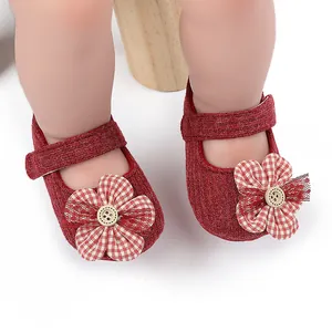 Primer plano detallado de zapatos rojos de punto para bebé con flor de cuadros