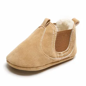 Vue rapprochée d'un chausson bébé en daim camel avec doublure chaude en fausse fourrure