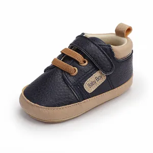 Detailed view of navy blue faux leather baby walker shoes with a cute Baby Boy patch