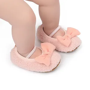 Primer plano de zapatos de bebé rosa de felpa suave con un lazo y correa elástica