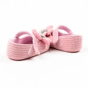 Macro view showing the soft knitted texture of pink baby princess walking shoes with flower