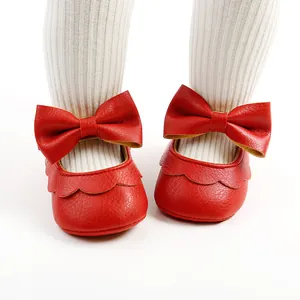 Detailed close-up of red PU baby princess shoes featuring a large bow and scalloped edge.