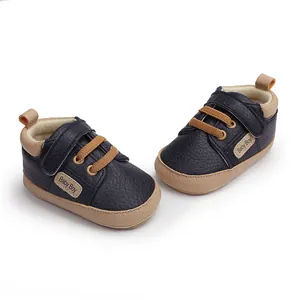 Close-up of navy blue infant walking shoes with Baby Boy label and velcro strap