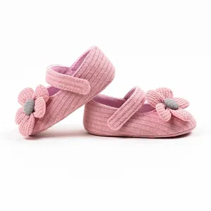 Close-up detail of soft pink knitted baby princess walking shoes with decorative flower